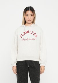 Ανοιχτό γκρι φούτερ με κορδόνι, διαθέτει κόκκινο κείμενο "ΑΤΕΛΕΙΩΤΟΣ" και "Τέλεια ατελής." Μαλακή, άνετη γραμμή, ριμπ μανσέτες και στρίφωμα.