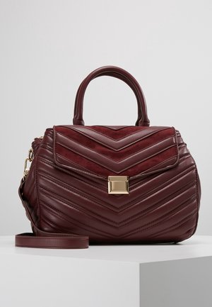 Bolso de mano en burdeos profundo con diseño acolchado en forma de chevron, forma estructurada, asa superior, correa desmontable y cierre con herrajes dorados.