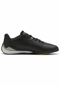 Schwarze Sportschuhe mit glattem synthetischem Obermaterial, Gummisohle und limettengrünen Akzenten. Verfügen über ein niedriges Profil und dezente Perforationen.