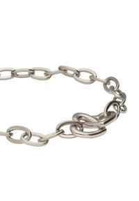 Pulsera de cadena de metal plateado con eslabones ovalados y circulares entrelazados, acabado pulido y formas de eslabones variadas.