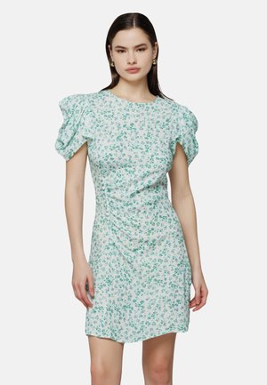 Blomstrede kjole med korte puffærmer, hvid bund og grøn blomsterprint, med sidesamling og tætsiddende silhuet.