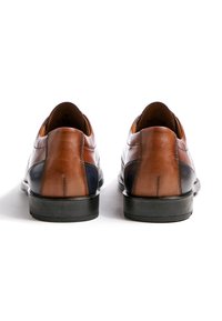 Braune Lederschuhe mit glatter Oberfläche, ausgestattet mit einer schwarzen Sohle und dunkelblauen Akzenten. Die Rückseite zeigt kontrastierende Farbeinsätze und Nahtverzierungen.