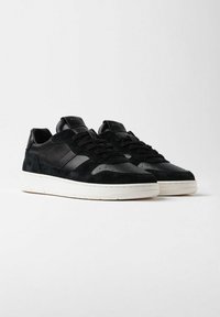 Sneaker nere in materiali di pelle e suede, con punta perforata, dettagli testurizzati, lacci piatti e suole in gomma bianca.