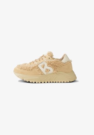 Beige sneakers with a fluffy wool-like upper, suede accents, and a chunky rubber sole. Features a raised white "B" logo on the side.