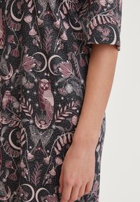 Tessuto nero con un dettagliato motivo rosa e bianco che presenta gufi, fiori, farfalle e lune, completato da una trama liscia.