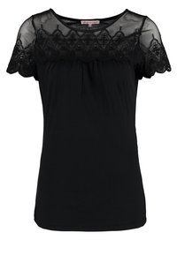 Haut noir avec un empiècement en dentelle transparente et des manches courtes à bords festonnés, tissu doux et détails froncés sous la poitrine.