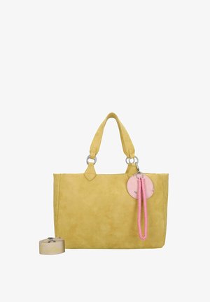 Sac fourre-tout en cuir jaune avec des détails en métal argenté, doté de deux poignées robustes, d'un pompon rose et d'une étiquette ronde avec une accentuation rose.