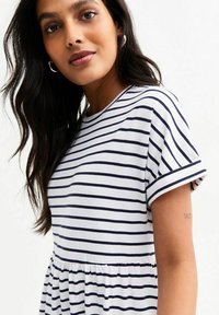 Abito a maniche corte a righe con scollo rotondo, caratterizzato da righe orizzontali blu navy e bianche, e una vita arricciata per maggiore volume.