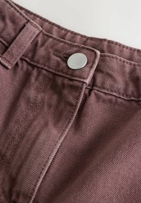 Mauve Baumwollhosen mit einem Metallknopf am Bund, ausgestattet mit einem strukturierten Gewebe und sichtbaren Nähten entlang der Säume.
