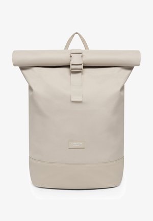 Beige rol-top rugzak met voorste gespsluiting, bovenste draaghandgreep en "Larkson Hamburg" label op het onderste voorpaneel.