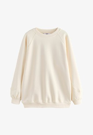 Felpa color crema chiaro realizzata in tessuto morbido. Presenta maniche raglan, polsini e orlo a costine, con una vestibilità comoda e una texture liscia.