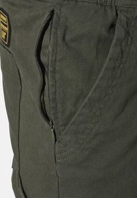 Dark green cargo shorts made of durable fabric, featuring a zippered pocket, visible stitching, and a relaxed fit design.