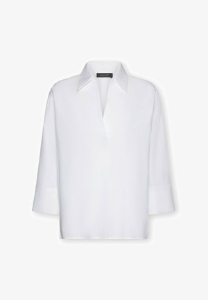 Blusa bianca in tessuto strutturato, con collo a punta, maniche a tre quarti e scollatura a V.