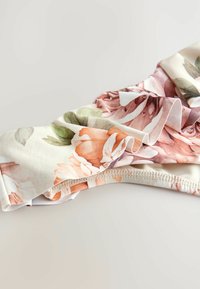 Květinová tkanina v broskvových, růžových a zelených odstínech; volánkový okraj; jemná textura; elastický pás na spodní straně; vhodná pro oděvy nebo doplňky.
