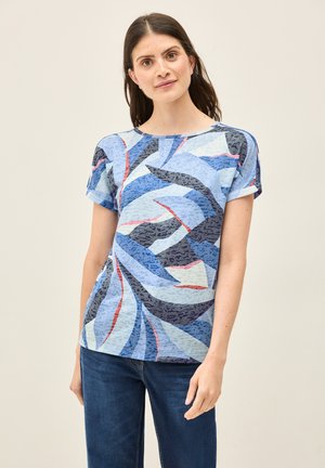 T-shirt à manches courtes dans différentes nuances de bleu, avec des motifs abstraits et des accents texturés. Col rond et coupe décontractée, associé à un jean.