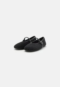 Black ballet flats with textured mesh fabric, round toe, and adjustable strap across the instep. Smooth sole and understated design.