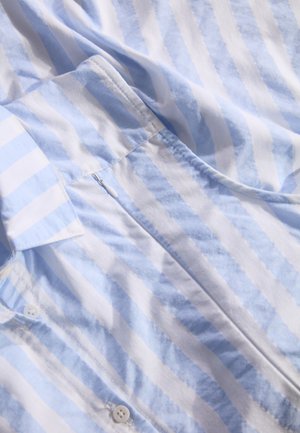 Chemise en coton rayée bleu clair et blanche avec fermeture à bouton et col rabattu, présentant une texture lisse et un éclat subtil.