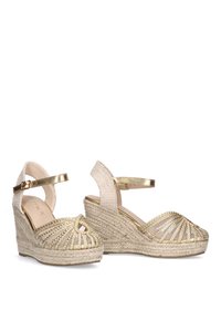 Sandalias de cuña de esparto doradas con diseño de punta abierta, suela de yute trenzado y correa en el tobillo. Accentos dorados texturizados y detalle de tacón entrelazado.
