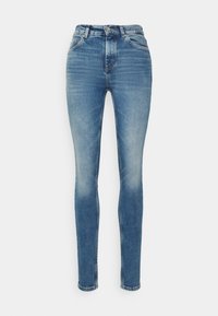 Kůže skinny jeans v светлém denim s vysokým pasem. Obsahuje pět kapes, klasické švy a mírné vyblednutí na stehnech.