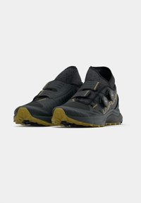 Czarne buty do biegania w terenie z teksturowaną cholewką, żółtymi i szarymi akcentami, pewnym systemem zapięcia oraz odporną podeszwą oferującą dobrą przyczepność.