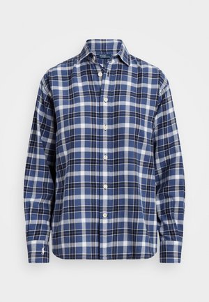 Chemise à manches longues boutonnée avec motif à carreaux bleu, blanc et noir et un col, présentée sur un fond blanc.