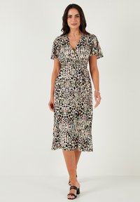 Floral print wrap dress in light fabric, featuring short sleeves and a mid-length hem. Dominant colors include white, black, red, and green accents.