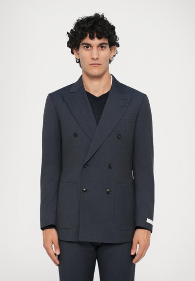 Námornícky dvojradový blazer z textúrovanej látky. Obsahuje klopové golier a čierne gombíky a dve predné vrecká. Prispôsobený strih.