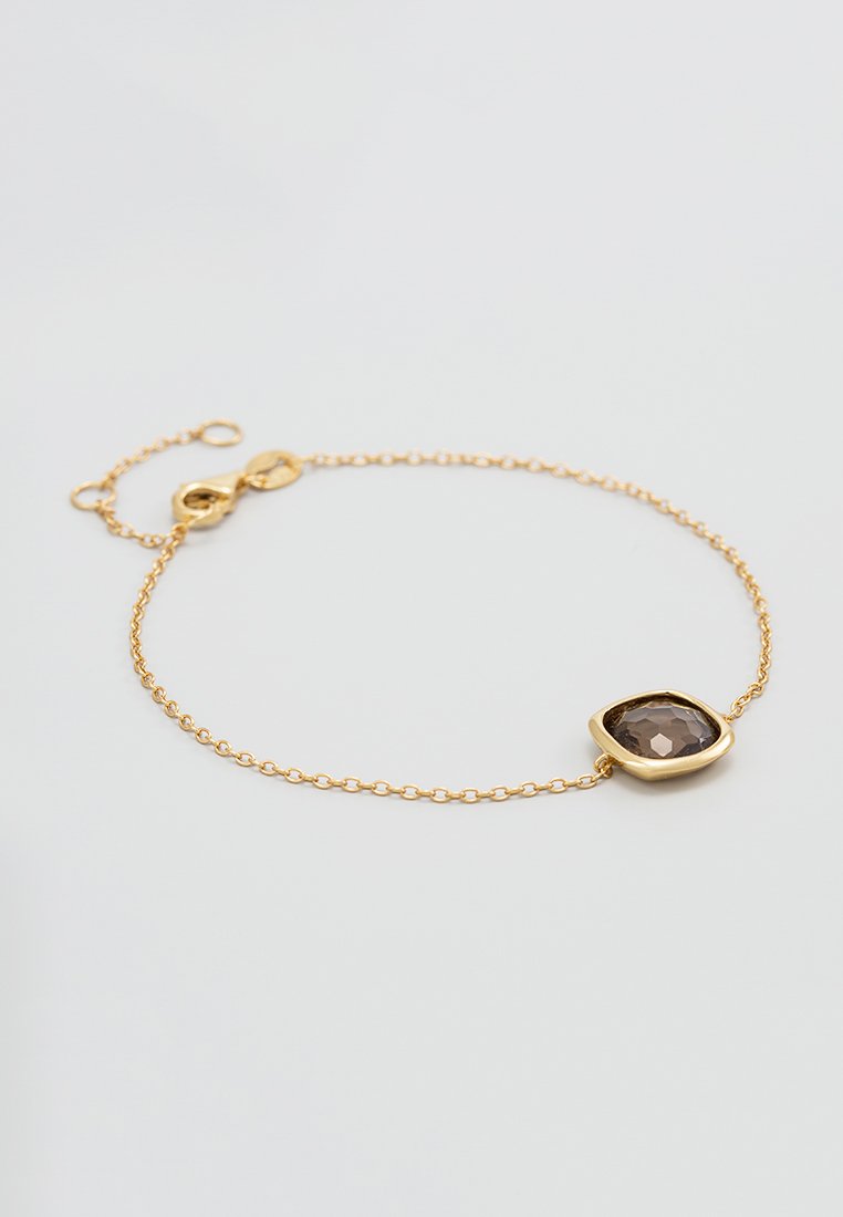Bracelet en chaîne dorée avec une pierre précieuse brune facettée sertie dans un cadre en métal doré arrondi. Longueur de chaîne ajustable avec un fermoir.