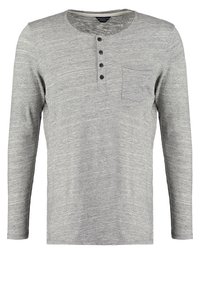 Maglietta henley a maniche lunghe grigio chiaro con quattro bottoni neri e una piccola tasca sul petto, realizzata in un tessuto morbido e testurizzato.