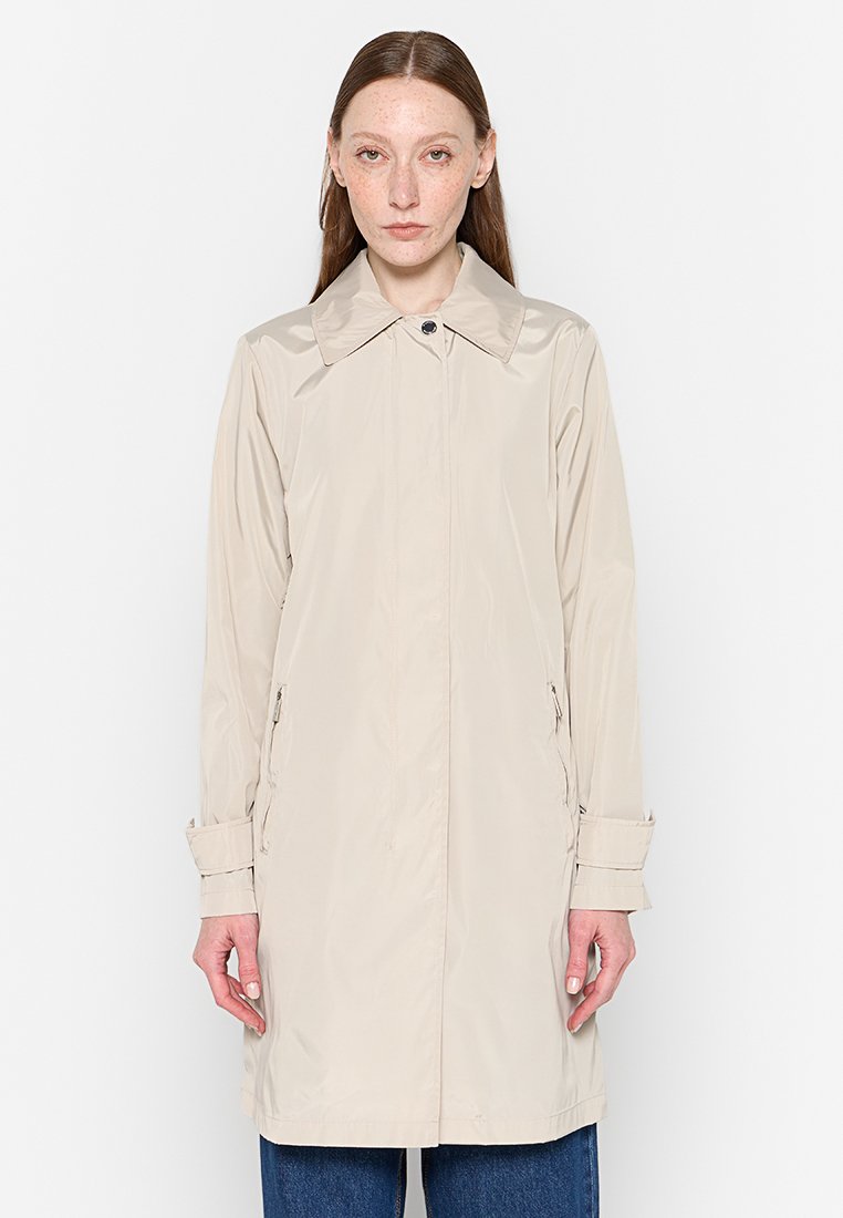 Imperméable de couleur crème avec un col pointu, fermeture à boutons sur le devant et deux poches latérales ; présente des manches longues avec des poignets ajustables.
