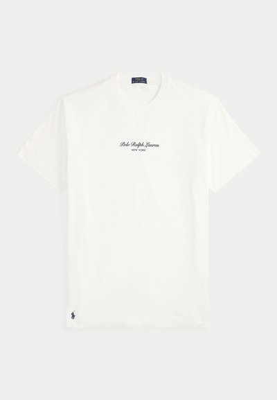 Λευκό μπλουζάκι με κοντό μανίκι με κείμενο "Polo Ralph Lauren New York" στο κέντρο του στήθους και μικρό ναυτικό λογότυπο Polo κοντά στο κάτω στρίφωμα.