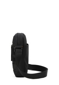 Borsa a tracolla nera con design cilindrico, caratterizzata da una struttura imbottita, tracolla regolabile e dettagli in velcro. Tessuto liscio e cerniere.