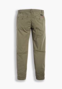 Pantalon décontracté vert olive avec poches arrière boutonnées et passants de ceinture, présenté à plat montrant le dos.