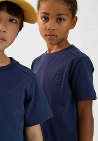 T-shirts en coton bleu marine avec des encolures rondes et des manches courtes, affichant un logo brodé subtil sur la poitrine.