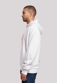 White hooded sweatshirt with front pocket, featuring graphic prints in orange, red, and black text, made of soft material with a relaxed fit.