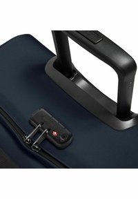 Mörkblå resväska med en texturerad tyg, dubbla dragkedjor och ett svart utdragbart handtag. Den har ett TSA-godkänt lås för säkerhet.