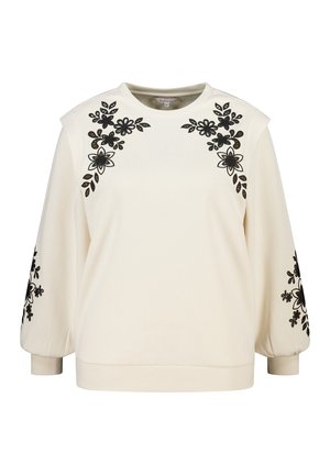 Crèmekleurige trui met zwarte bloemige borduursels op de schouders en mouwen. Zachte textuur, ronde halslijn en geribbelde boorden aan de zoom.