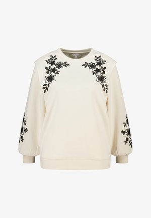 Crèmekleurige trui met zwarte bloemige borduursels op de schouders en mouwen. Zachte textuur, ronde halslijn en geribbelde boorden aan de zoom.