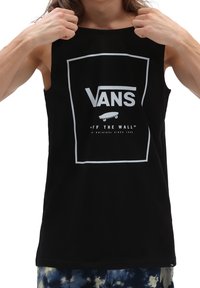 T-shirt senza maniche nera in cotone con una grafica bianca che presenta la scritta "VANS" e un'icona di skateboard, centrata all'interno di una cornice rettangolare.