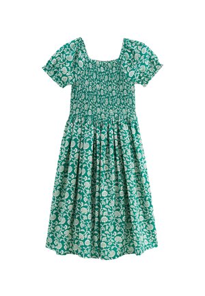 Robe florale verte avec des manches courtes bouffantes, un décolleté carré et un corps smocké. Présente des motifs de feuilles et de fleurs blanches sur toute la surface.
