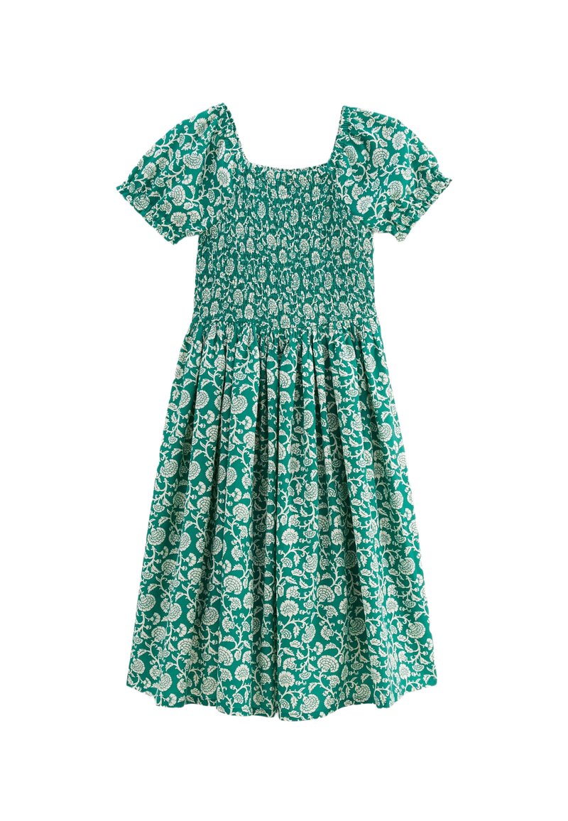 Robe florale verte avec des manches courtes bouffantes, un décolleté carré et un corps smocké. Présente des motifs de feuilles et de fleurs blanches sur toute la surface.