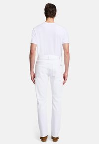 Białe dżinsy o prostym kroju nogawki, z tylnymi kieszeniami i teksturowanym materiałem. W połączeniu z gładką, białą koszulą z krótkim rękawem.
