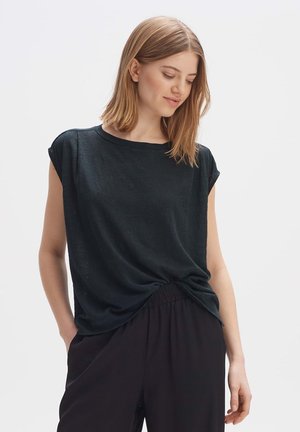 T-shirt nera a maniche corte realizzata in tessuto leggero, caratterizzata da una vestibilità comoda con un dettaglio annodato in vita, abbinata a pantaloni larghi.