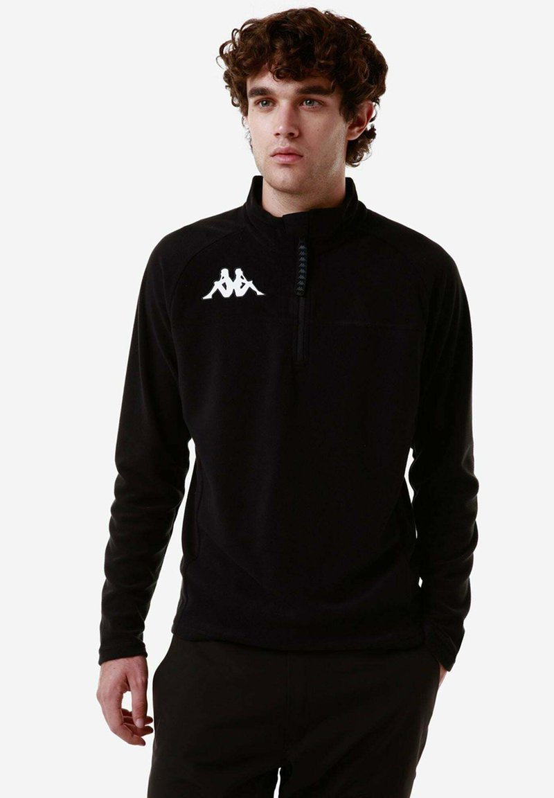 Pullover in pile nero con zip a metà, dotato di collo alto e logo bianco sul lato sinistro del petto. Texture morbida e maniche lunghe.