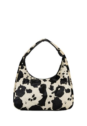 Sac à bandoulière imprimé vache noir et blanc avec une poignée supérieure incurvée et une forme rectangulaire arrondie sur un fond blanc.
