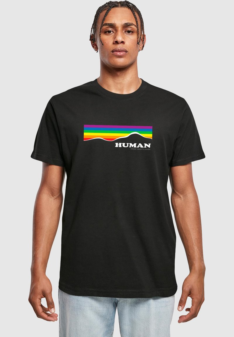 Black cotton t-shirt featuring a colorful rainbow wave graphic with the word "HUMAN" below, set against a light gray background.