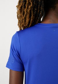 Karaļzili sporta t-krekls ar mīkstu faktūru, īsām piedurknēm un smalku logotipa detaļu uz piedurknes.