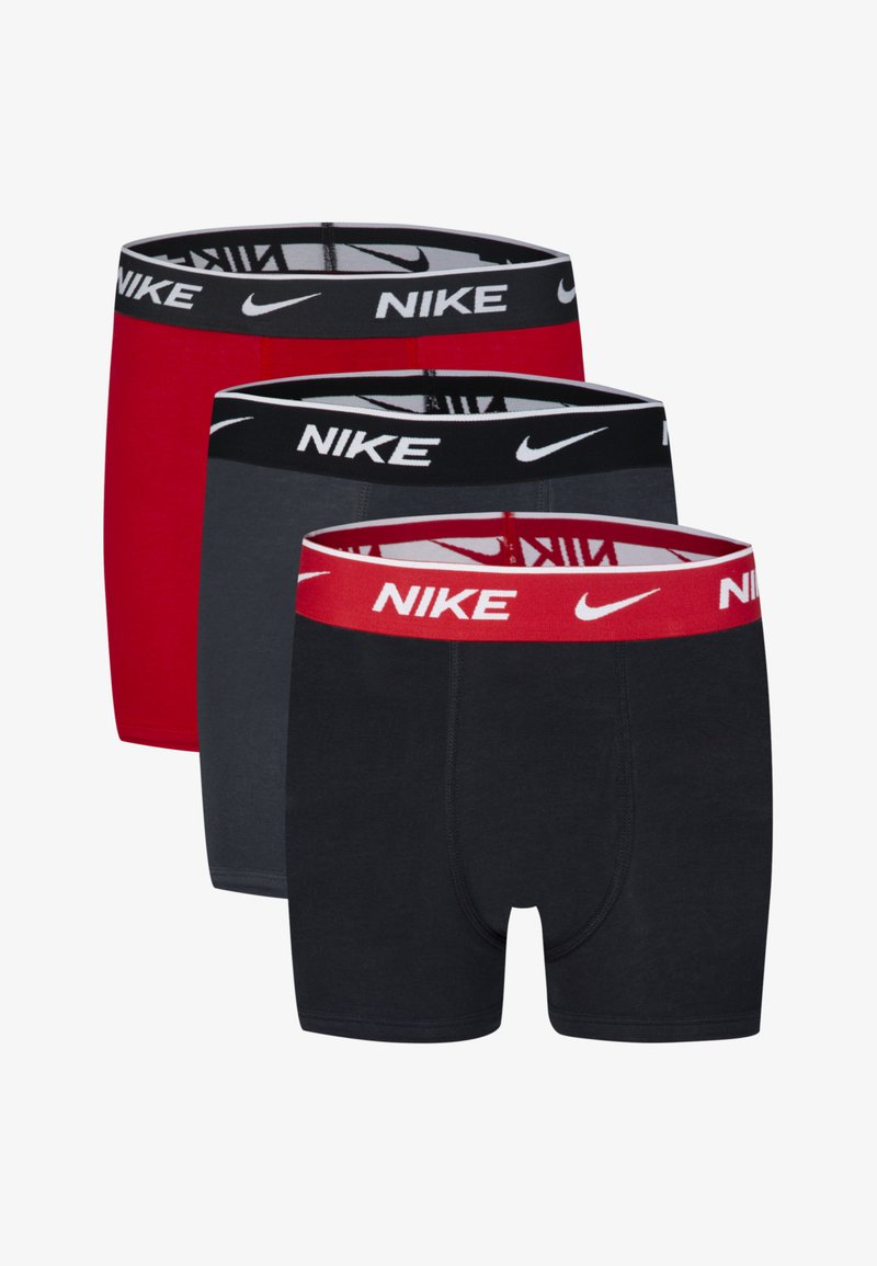 Tri para bokser hlačk: ene rdeče, ene sive in ene črne, vsake s Nike logotipom na elastičnem pasu.