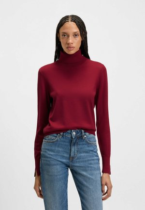 Burgundy turtleneck sweater in ribbed texture, long sleeves, fitted design, paired with high-waisted blue denim jeans. Simple and classic.