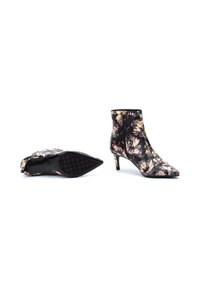 Botines florales negros con punta afilada, tela texturizada y tacón tipo kitten de 5 cm. Cuenta con una cremallera lateral y una suela con estampado.